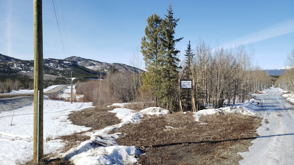 Photo with sign of the Yukon Dog Mushers Association 
